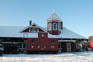 Snoqualmie Depot in the snow with White River Lumber Co caboose in front.