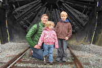 Junior donor Hal stands with his sister and dad at the Rotary Snowplow after donating his piggy bank savings to help repair the track after the January 2009 flood damage.