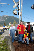 Volunteers stand next to new Safetran model S-40 gate mechanism they installed at Bendigo Blvd in North Bend.