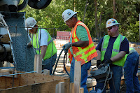 Construction workers pouring foundation for Train Shed Exhibit Hall.