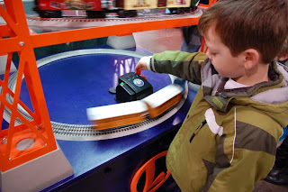 Boy playing with model train during a train show.