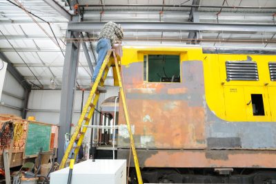 Applying paint to White River Lumber Co locomotive 1.