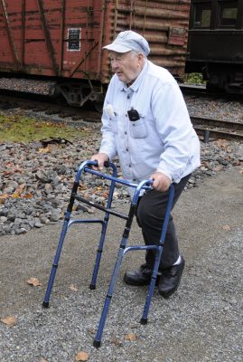 Man arriving at Train Shed with assistance of a walker.