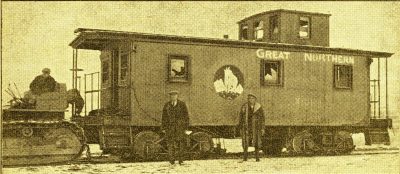 Great Northern Caboose X101 being pulled by tractor.