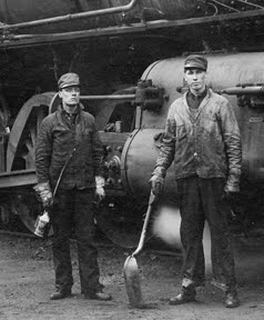 Which one is the fireman and which one is the engineer? Here is a hint: the fireman was responsible for shoveling coal as well as cleaning out the boiler, jobs he probably would have used a coal scoop for. Meanwhile, the engineer was responsible for oiling bearings and sliding surfaces before departure. George Longworth is on the left and is the engineer (holding his tool of the trade, an oil can), his fireman is on the right holding his shovel. Sometimes the fireman can be spotted simply because his clothes are noticeably dirtier from coming into contact with all that coal dust! Northwest Railway Museum Collection
