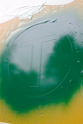 The "T" in the Weyerhaeuser W/T logo is evident under the paint mask as the three layers of paint that make up the logo are applied.