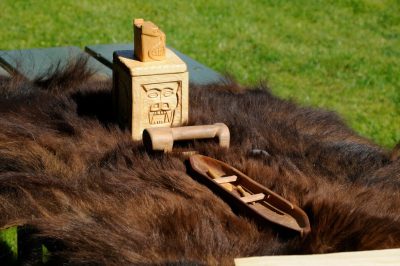 An animal skin rests upon a table with wood carvings sitting atop the skin. All are from the Snoqualime Nation, on display during Snoqualmie Railroad days 2011.