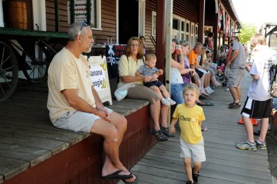 Passengers sitting along the Snoqualmie Depot boardwalk, waiting to board the Northwest Railway Museum's excursion train.