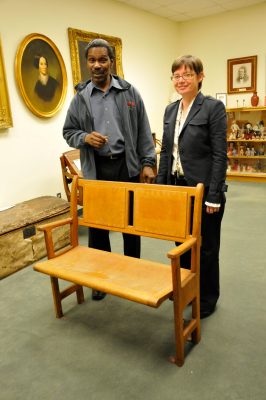 ABHS Archivists stand behind preserved chapel car pew.