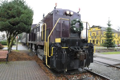 Locomotive 2024 sits with the Santa Train. On the front of the locomotive hangs a wreath, and small illuminated plastic Santas display from the markers.