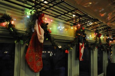 Garland, lights, and Christmas stockings hang from the luggage racks in Spokane, Portland & Seattle 272.