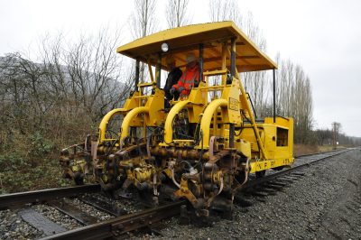 Former Northern Pacific Jackson Tamper #145 tamps track near the NW 8th St crossing in North Bend.