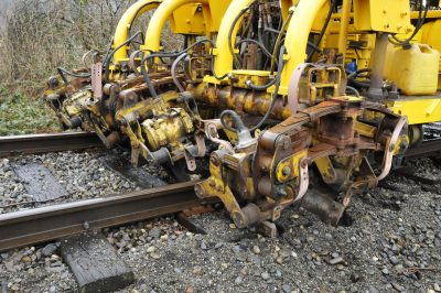 Northern Pacific Jackson Tamper #145 has its tamping heads in the ballast tamping a tie.