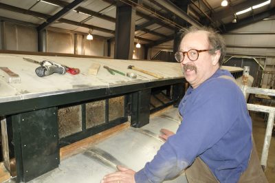 Lead Messenger of Peace restoration worker Kevin P. stands next to the clearstory of the car. Clearstory windows have begun to be installed.