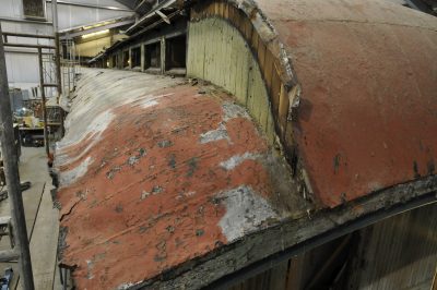 The original 1898 Terne metal roof on Chapel Car Messenger of Peace. The roof is flaking paint, and the metal covering is worn and showing damage.