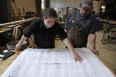 Randy Miller (left) points out an item on a new drawing for Messenger of Peace for Project Lead Kevin Palo (right) in the CRW.