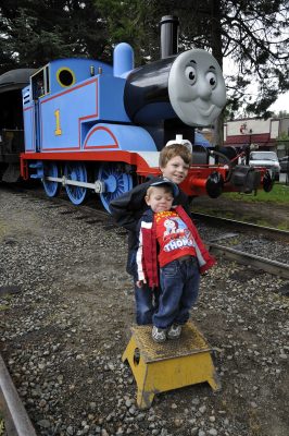 Two young boys stand on a step box in front of Thomas at DOWT 2012. They both have goofy expressions on their faces.