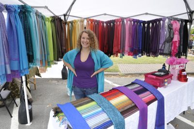 A smiling vendor stands with a rainbow array of scarves behind her during Snoqualmie Railroad Days 2012.