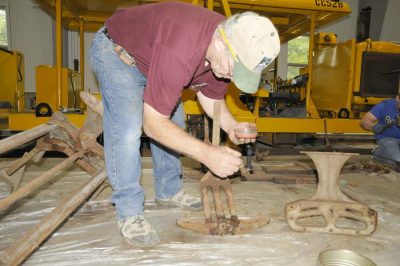 Volunteer rehabilitating seat frames for SP&S 218 in the CRW