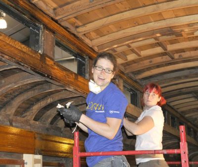 Day of Caring 2012 volunteers strip shellac in Messenger of Peace