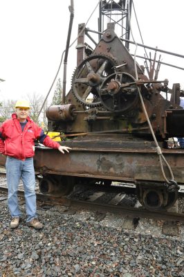 New owner Jon Burget poses with the 1903 steam crane prior to its lift.