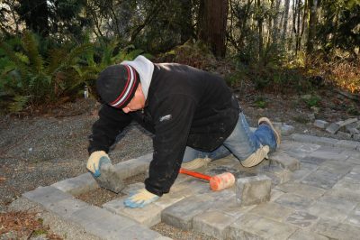 Pavingstone Supply worker installing pavers at east end of Train Shed.