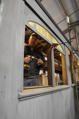 Bob McN. poses for a photo while installing an arched colored glass panel on SP&S 218.