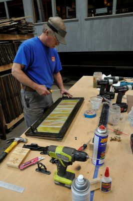 Volunteer installs Dayton Manufacturing hinges on a SP&S 218 clerestory window.