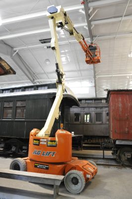 An articulated manlift inside the Train Shed replacing smoke detectors.