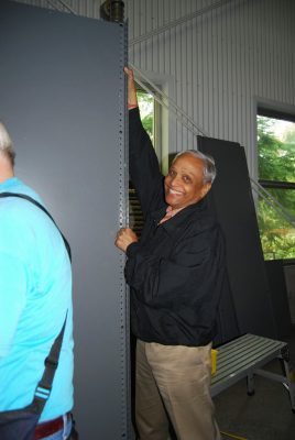 Day of Caring 2013 volunteer holding a piece of shelving in the Train Shed.