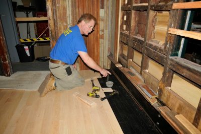 A volunteer points out work on the new floor for SP&S 218.