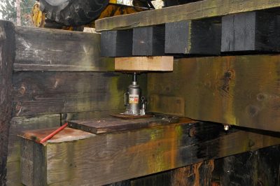 A jack lifting bridge deck and stringers for replacement of caps on Bridge 35.