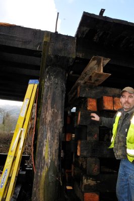 A worker stands next to timbers temporarily supporting Bridge 35 decking during repairs.