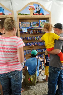 Families stand in front of a Thomas Wooden Railway display in the retail tent for DOWT 2014.