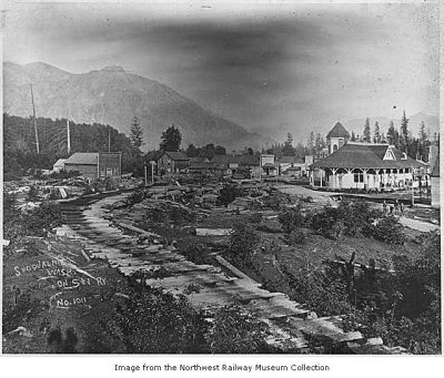 1897 photo showing downtown Snoqualime as well as the backside of the Snoqualmie Depot. A skid row comes away from the depot and towards the photographer.