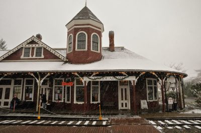 A festively decorated Snoqualmie Depot gathers snow on its roof during snowfall at Santa Train 2014.