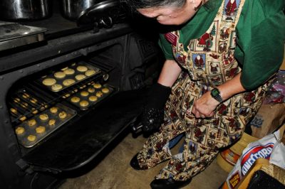 Volunteer Kathy S. checks on cookies in the kitchen car's stove during Santa Train 2014.