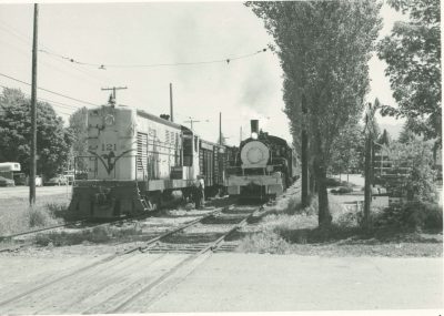 PTS #121 at Northern St Crossing waiting on siding with a freight train as US Plywood #11 rolls by on the main with a passenger train sometime in the mid 1980's.