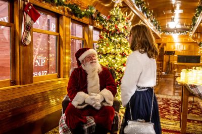 Santa visits with a young visitor in the chapel car during Santa Train