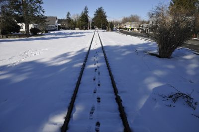 The rail line in downtown Snoqualmie with snow on the ground. Boot prints can be seen between the two rails.