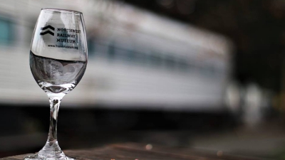NRM logo wine glass in the foreground with one of the stationary coaches out of focus in the background