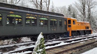 Orange locomotive 4024 pulling the train set on a snowy winter day.