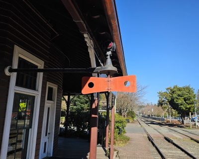 The train order board at Snoqualmie Depot in the "Stop" aspect as seen from the platform.  The board is perpendicular to the tracks, and the red lights are displayed.