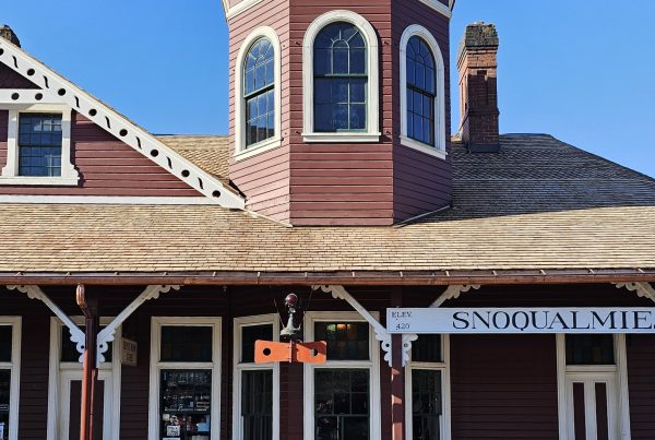 The front of the Snoqualmie Depot with the turret and train order board in the sun.