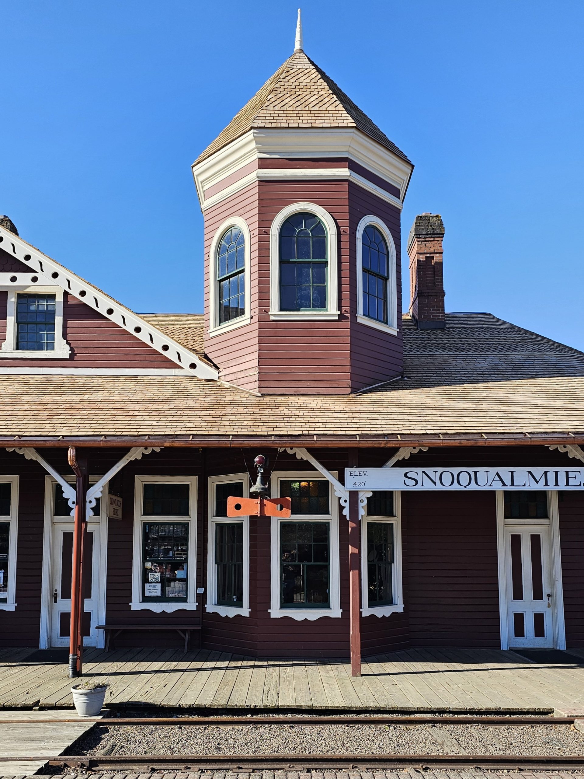 The front of the Snoqualmie Depot with the turret and train order board in the sun.