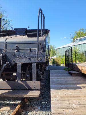 Northern Pacific 924 and tender sits next to the REC platform. The handrail from the locomotive sticks out into the edge of the platform.