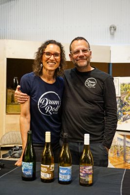 Drum Roll Wines representatives standing in front of a table displaying their four wines.