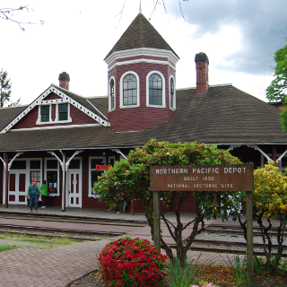 Snoqualmie Depot with the historic site sign in front of it.