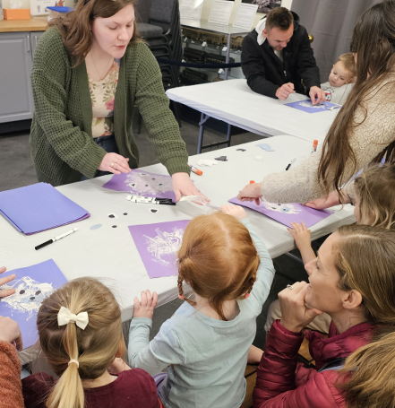 A Museum educator guides children in a hands-on crafting activity during Story Time.