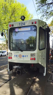 Portland's TriMet MAX Type 1 LRV rests in the shade at Holladay Park. Farewell messages are written on it, with visitors write more on its sides.